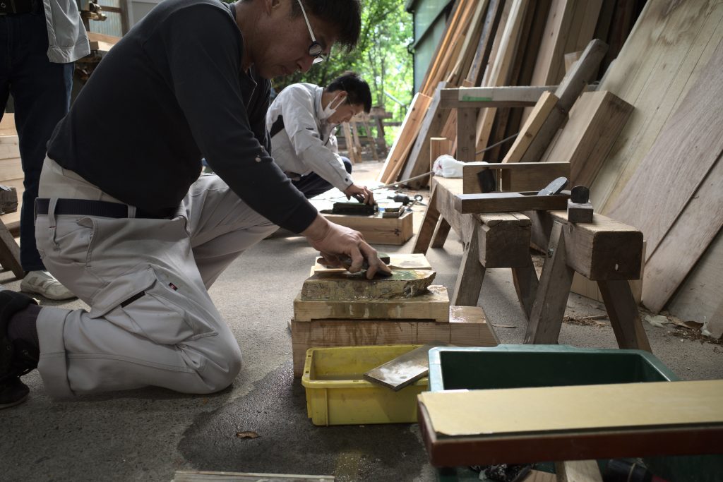 鉋の刃を研ぐ大工